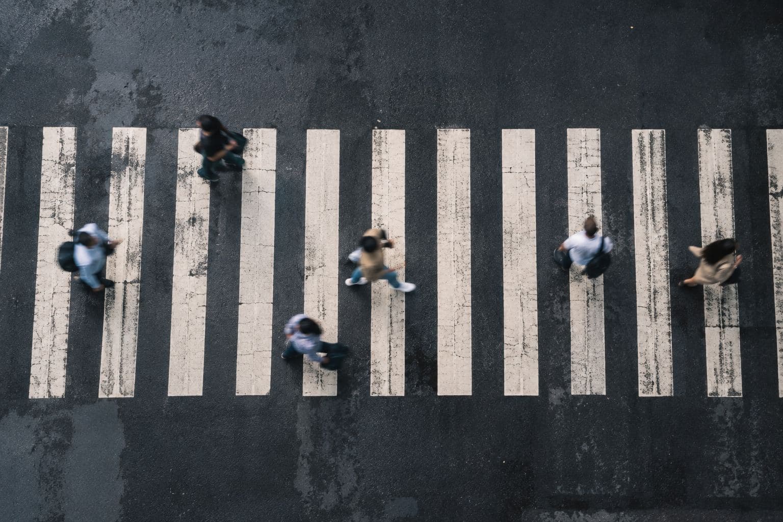 People crossing a street, seen from directly above.