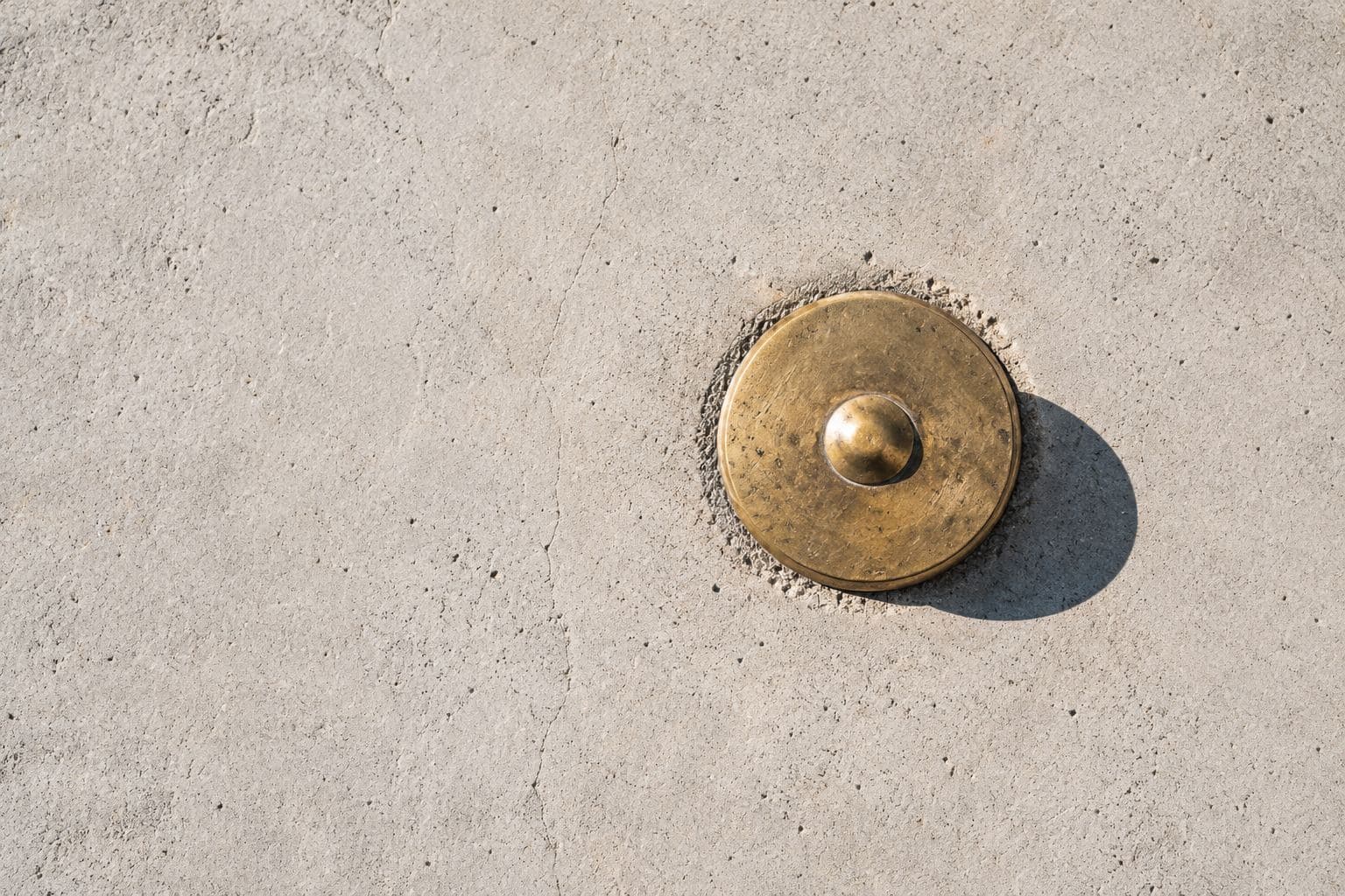 A brass survey marker set into concrete.