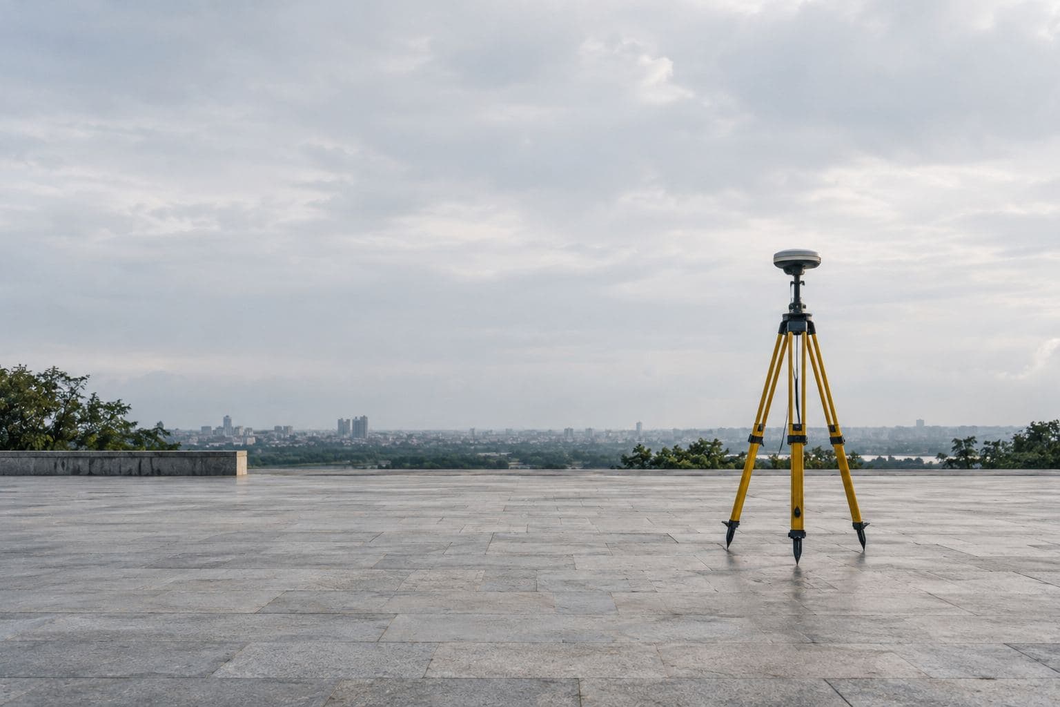 A GPS receiver on a tripod in an empty plaza.